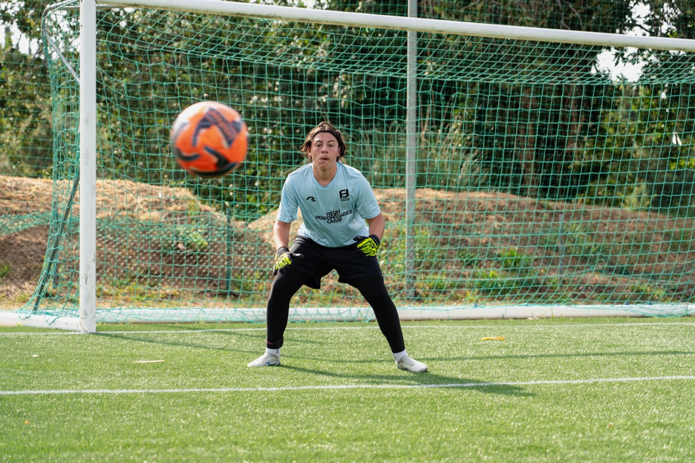 Portero preparado para detener un disparo durante el entrenamiento
